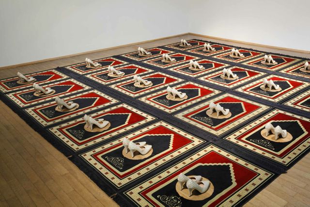 Zoulikha Bouabdellah, Silence, 2008-2014, Installation: 24 prayer rugs, 24 pair of shoes 300 x 560 cm. Courtesy: the artist © Zoulikha Bouabdellah