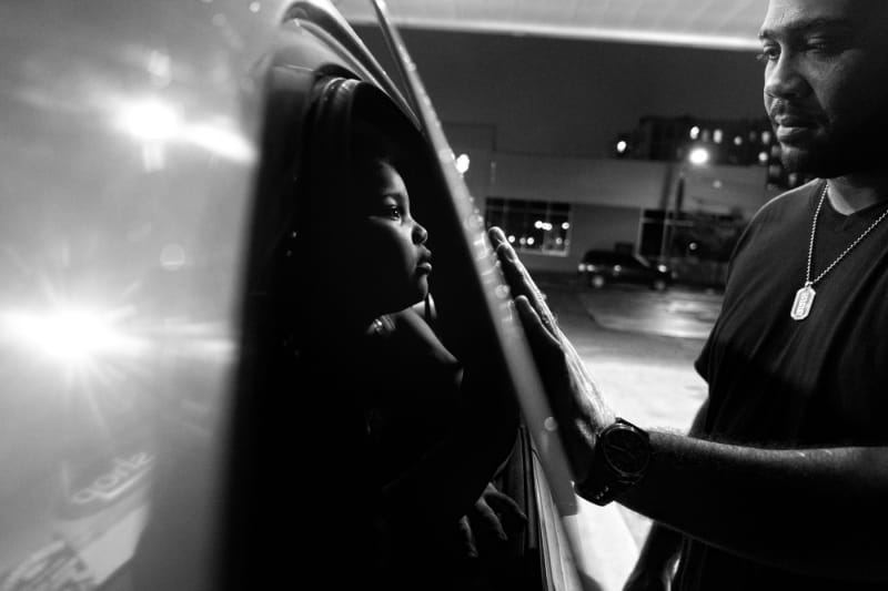 Billy Garcia and daughter Esmeralda enjoy a tender moment at a gas station. Bronx, NY, 2012. © Zun Lee 