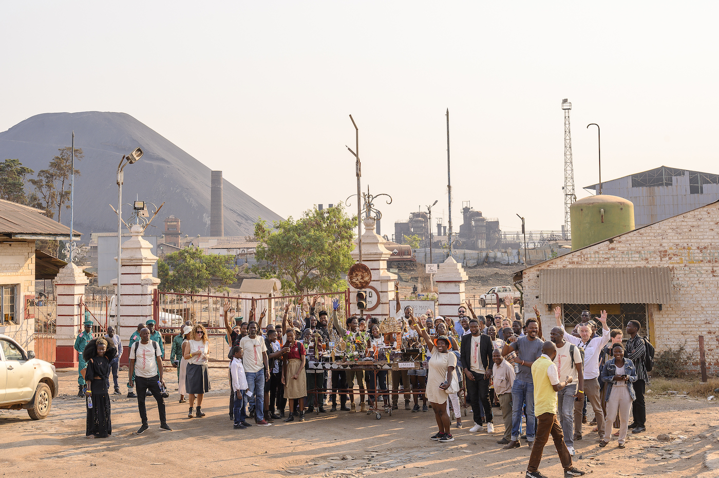 Arsène Mpiana. Description: The Biennale crowd/partakers in front of the slag heap/terril of the former Gécamines mining site.