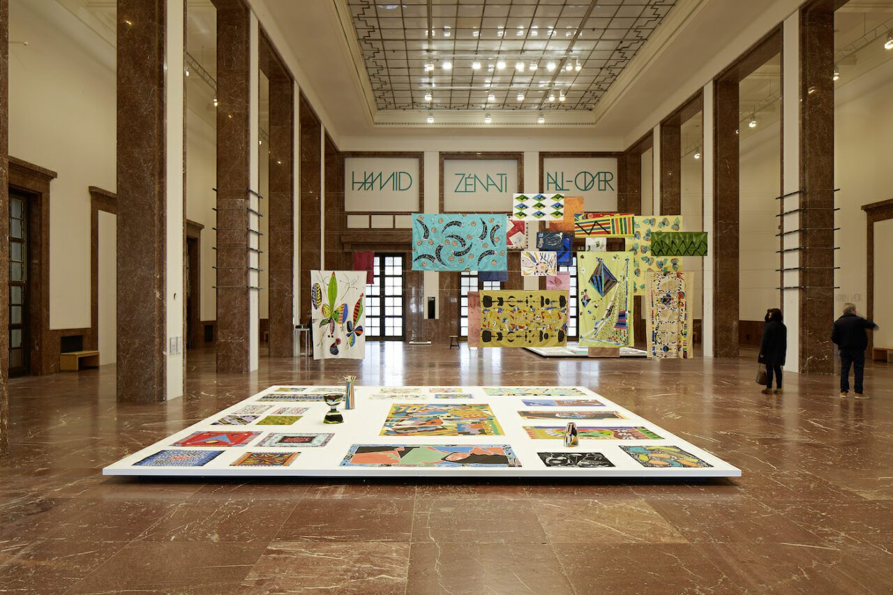 ”Hamid Zénati. All-Over”, installation view, Haus der Kunst, 2023
In line with the artist’s self-described “all-over” aesthetic principle, Hamid Zénati’s vibrant textile works fill the Mittelhalle of Haus der Kunst.
Photo: Judith Buss

