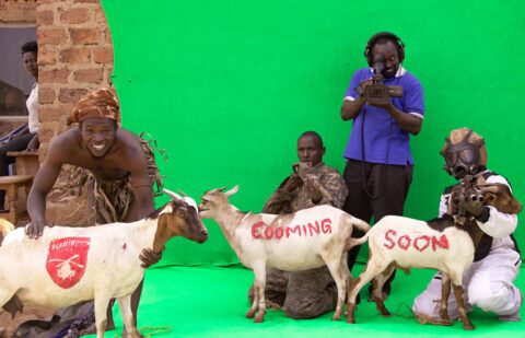 ISAAC NABWANA, STANDING AT CENTER, WITH HIS CREW IN “ONCE UPON A TIME IN UGANDA.” CREDIT: MATT PORWOLL/YELLOW VEIL PICTURES/DRAFTHOUSE FILMS
